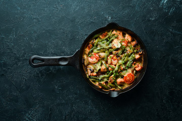 Baked beef with beans, tomatoes and vegetables in a frying pan. Top view. Free space for your text.