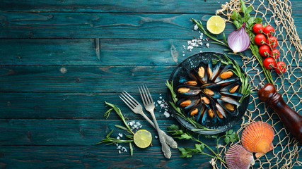 Mussels with spices and rosemary. Seafood on black background. Top view. Free copy space.