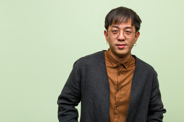 Fototapeta premium Young chinese man wearing a cool clothes style against a green background