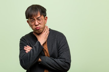Young chinese man against a green wall