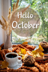Hello October autumn background. Coffee cup, books, donuts, warm plaid and autumnal leaves on a window sill in autumn. Cozy home, breakfast, reading, comfort concept © missmimimina