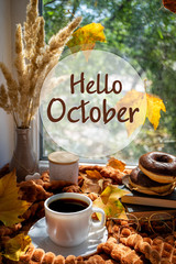 Hello October autumn background. Coffee cup, books, donuts, warm plaid and autumnal leaves on a...