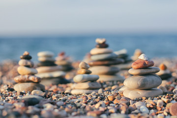 Zen pyramid of spa stones on the blurred sea background. Sand on a beach. Sea shores. Place for...