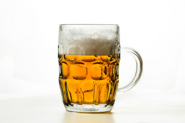 foamy beer in a transparent glass on a white background