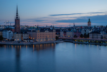 Fototapeta na wymiar A colorful sunrise over Stockholm with the lights reflecting on the calm water of the sea - 4