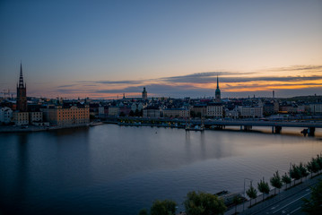 Fototapeta na wymiar A colorful sunrise over Stockholm with the lights reflecting on the calm water of the sea - 10