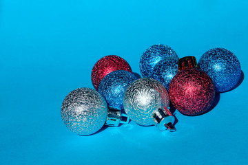 Christmas decoration over blue background. Holidays, Christmas toys concept. Blue, red and silver Christmas balls over blue background.