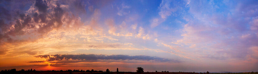 Bright sunlight through the clouds against a breathtaking evening sky at sunset. panorama, natural composition