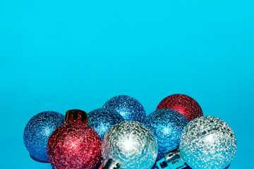 Christmas decoration over blue background. Holidays, Christmas toys concept. Blue, red and silver Christmas balls over blue background.