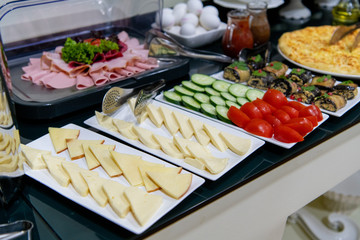 Rows of fresh cheese of different varieties, sauces and vegetables. Cheese as the main snack at...