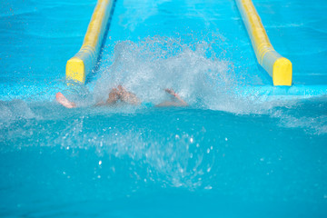 Colorful plastic water slides in waterpark. Water splashes are all over.