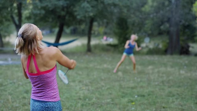 Pretty sporty fitness Girls are Playing Badminton In Park. outdoor activity, picnic with friends, sport games, healthy lifestyle, slow motion fullHD stock footage.