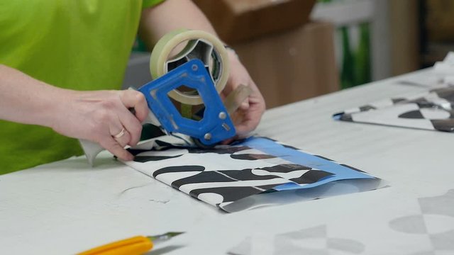 Female hands pack products at the factory