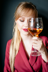woman in red holding wine glass and smiles