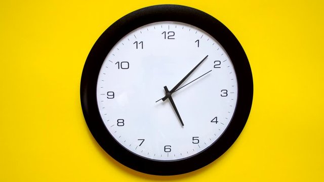Office clock on yellow wall work at evening time. 4k.