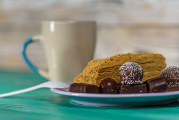 A piece of sponge cake lying on a plate, on a wooden background.