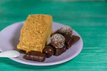 A piece of sponge cake lying on a plate, on a wooden background.