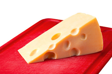 Cheese with holes on red board isolated on white