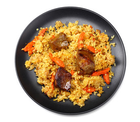 pilaf with meat on black plate isolated on white background. top view