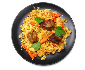 pilaf with meat on black plate isolated on white background. top view