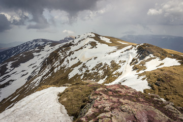 Impressive view from a Midzor summit, the highest peak of Old mountain, during transition period between winter and spring with some remaining snow and sunlit highlands