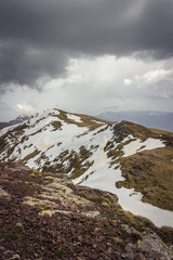 Impressive view from a Midzor summit, the highest peak of Old mountain, during transition period between winter and spring with some remaining snow and sunlit highlands