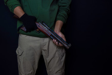 asian man holds a gun. Gun in his hand isolated on black background.