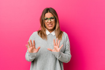 Young authentic charismatic real people woman against a wall rejecting someone showing a gesture of...