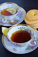 Fresh fragrant tea with lemon in a beautiful Cup on a black background.