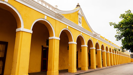 Building of the vaults in Cartagena, Colombia, an architectural succession of arches and columns in yellow and white