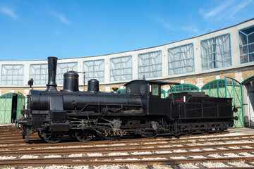 Fototapeta na wymiar Steam engine in front of a sector-shaped garage
