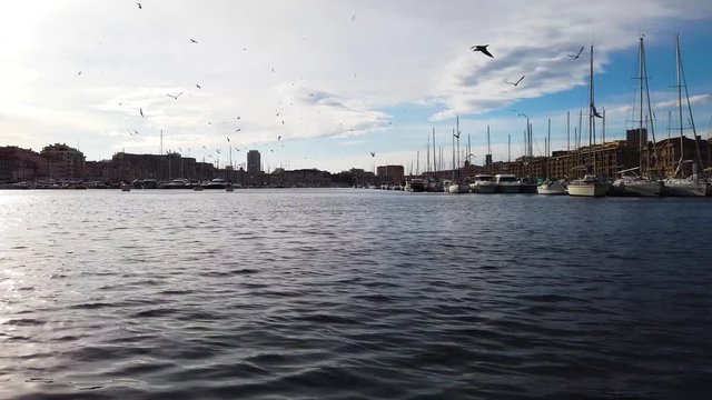 Marseille city, France. Panoramic view from waterfront on marina sailboats seagulls. UHD 4K cinematic stock footage about French Riviera, Mediterranean Coast, South European life, travel, culture.