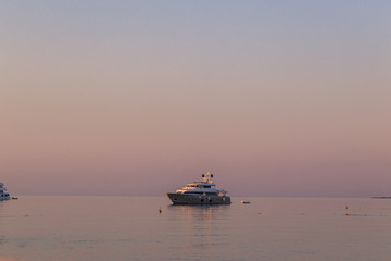 Fototapeta na wymiar Luxury yacht on open sea at pink sunrise
