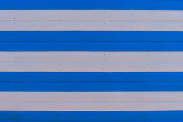 Extreme close up of white and blue striped wooden beach hut on a sunny day. English style of coastal living. Sussex, Great Britain