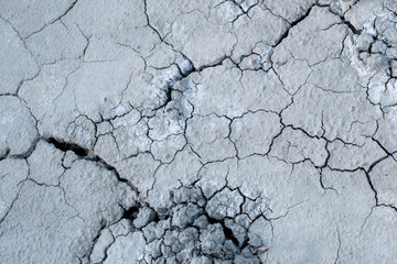 dry land cracks grey gray grayscale earth ground dried cracking background landscape terraine hilly surface
