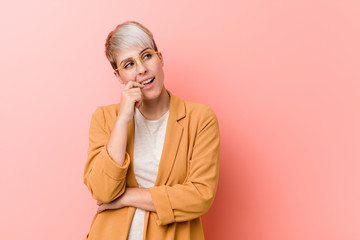 Young caucasian woman wearing a casual business clothes relaxed thinking about something looking at a copy space.