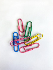 Multi-colored paper clips on a white background, photographed close-up