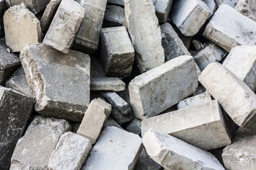 Pile of disassemble gray concrete bricks. close-up of scattered stone pavement bricks texture.