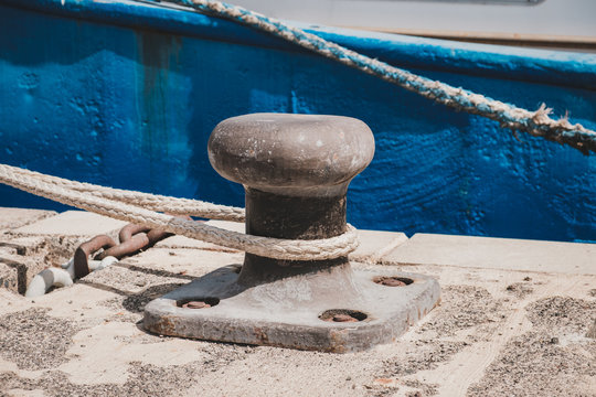 Rope of a ship or boat moored to a bollard at harbor closeup