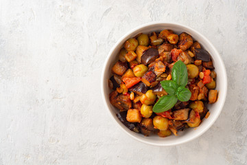Traditional sicilian eggplant dish Caponata in bowl on concrete background. Top view. Copy space.