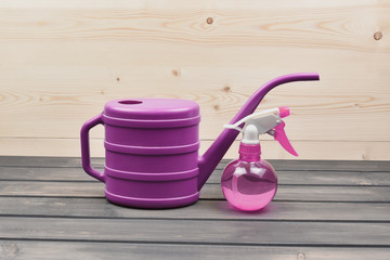 Watering-can and houseplants sprayer for watering of houseplants on a wooden table