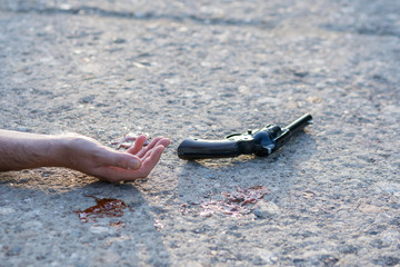 hand and gun at murder scene
