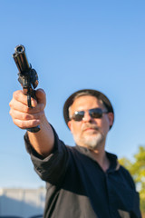 male criminal pointing and shooting a gun replica