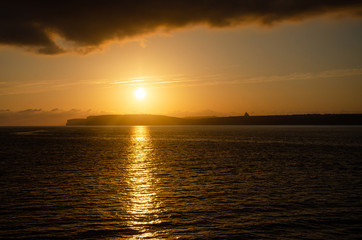 Fototapeta na wymiar Sunset over sea in Gozo, Malta. Golden orange sunset. Mediterranean Sea