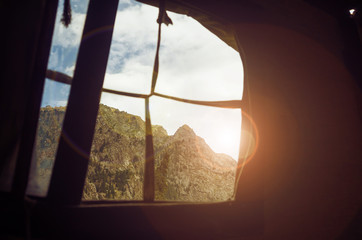 A beautiful mountain view through the window of a tent