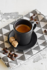 A cup of fragrant espresso in a beautiful clay cup. Two pieces of cane sugar.