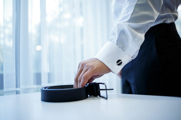 man puts on a suit on the wedding day