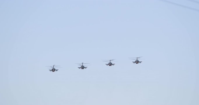 Column of four military helicopters flies over the ground. Military helicopters and planes in the evening sky. Air force parade. Independence Day parade in the CIS country. Belarus 3 July 2019.