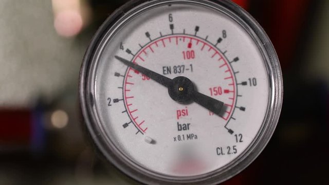Pressure gauge in a factory, arrow movement on an industrial pressure gauge. Industrial pressure gauge