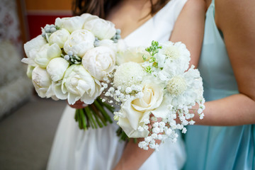 Beautiful wedding bouquet of flowers in the hands of the newlyweds